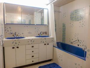 a bathroom with two sinks and a tub at Apartment Jeanne D'Arc Apt- H-58 by Interhome in Crans-Montana