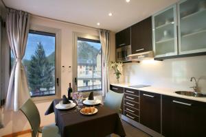 a kitchen with a table and a dining room at La Faiada in El Pont de Suert