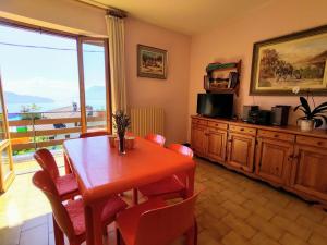 a dining room with a table and chairs and a balcony at Apartment Cinzia by Interhome in Vercana