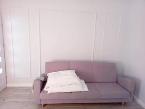 a purple couch with two pillows on it in a room at Rewianka Apartamenty przy samej plaży in Rewa
