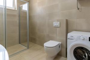 a bathroom with a toilet and a washing machine at Sea View Luxury Apartment in Cres