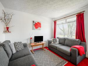 a living room with two couches and a tv at Holiday Home Lochness by Interhome in Contin +17 photos