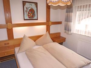 1 dormitorio con cama blanca y cabecero de madera en Apartment Schimpfössl Katharina-3 by Interhome, en Sankt Anton am Arlberg