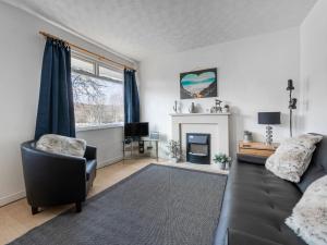 a living room with a black couch and a fireplace at Holiday Home Isle of Skye by Interhome in Contin