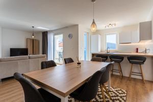 a kitchen and living room with a wooden table and chairs at Sea View Luxury Apartment in Cres +30 photos