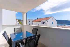 a glass table on a balcony with a view of the water at Sea View Luxury Apartment in Cres