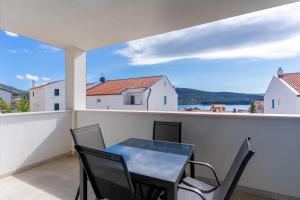 a table and chairs on a balcony with a view of the water at Sea View Luxury Apartment in Cres