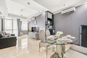 een woonkamer met een glazen tafel en stoelen bij Central by Kozystay - Mega Kuningan in Jakarta