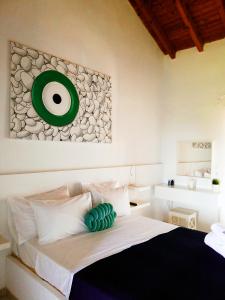 una camera da letto con un letto con un bersaglio verde sul muro di Rigas Rooms a Città di Skiathos