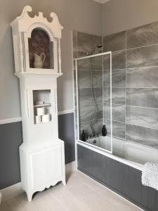 een badkamer met een wit bad en een douche bij Cornerways in Ventnor