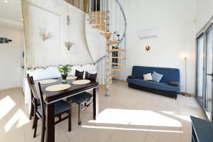 uma sala de estar com uma mesa e um sofá azul em Dúplex Luminoso en el centro de CADAQUÉS em Cadaqués