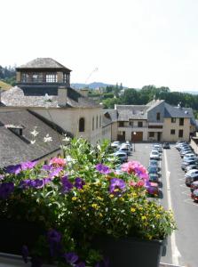 a view of a parking lot with flowers on a balcony at Hôtel de France in Espalion