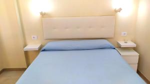 een slaapkamer met een bed met 2 nachtkastjes bij Holiday rent Fuerteventura in Costa de Antigua
