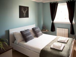 ein Schlafzimmer mit einem Bett mit Handtüchern darauf in der Unterkunft Pass the Keys Lovely 2-bed in Perfect City Location with Parking in Glasgow