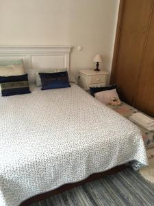 瓦倫薩的住宿－St Peter Cottage，卧室配有白色的床,上面放着一只狗
