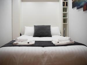 1 dormitorio con 1 cama con sábanas y almohadas blancas en Pass the Keys Cosy 1 bed next to SEC, OVO Hydro, Finnieston, en Glasgow