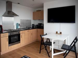 cocina con mesa y TV en la pared en Pass the Keys Cosy 1 bed next to SEC, OVO Hydro, Finnieston, en Glasgow