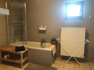 a bathroom with a bath tub and a window at Au Coeur des Collines, Charmette in Ellezelles