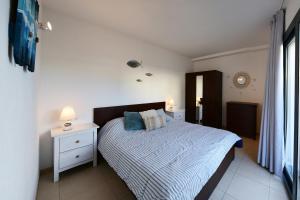 Schlafzimmer mit einem Bett mit einer blauen und weißen Bettdecke in der Unterkunft Apartamento luminoso en el centro de CADAQUÉS in Cadaqués