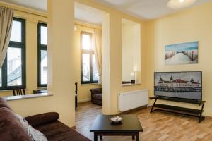 Una sala de estar con un sofá y un televisor de pantalla plana. en Strandvilla Ostpreussen - Dependance Strandhus, en Ahlbeck