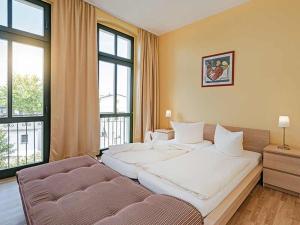 ein Schlafzimmer mit einem großen weißen Bett und einem Sofa in der Unterkunft Strandvilla Ostpreussen - Dependance Strandhus in Ahlbeck