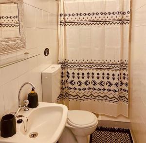 a bathroom with a white toilet and a sink at HOKKUM STUDIOS in Kokkari