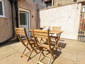 two chairs and a wooden table on a patio at Bay Cottage No 5 in Morecambe