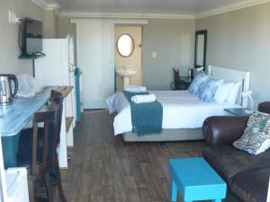 Habitación de hotel con cama y sofá en House of 2 Oceans, en Agulhas