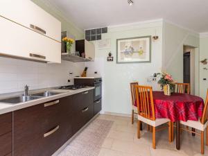 una cucina con tavolo, sedie e lavandino di Apartment Cristina by Interhome a Riva Ligure