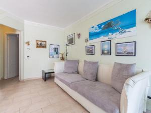 un soggiorno con divano e immagini appese al muro di Apartment Cristina by Interhome a Riva Ligure