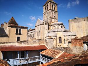 an old building with a clock tower and roofs at Le Clou in Chauvigny