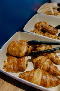 three trays of pastries and croissants on a table at Hôtel Le Windsor Biarritz in Biarritz