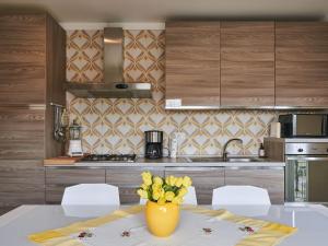 a kitchen with a table with a vase of yellow flowers at Holiday Home Anna by Interhome in Luino