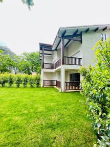 a house with a green lawn in front of it at Studio mansardé climatisé les roseaux bord de lac in Biscarrosse
