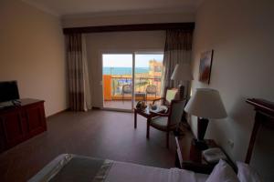 ein Hotelzimmer mit einem Bett, einem Schreibtisch und einem Fenster in der Unterkunft Stay Inn Hotel Ain Sokhna in Ain Suchna