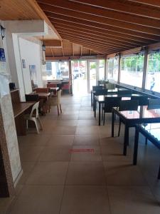 a dining room with tables and benches and windows at GÜVEN HOTEL in Canakkale