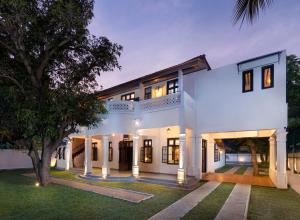 an exterior view of a white house with a tree at Jetwing Mahesa Bhawan in Jaffna