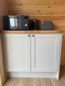 a white cabinet with a microwave on top of it at Wall park touring Centry road camping in Brixham