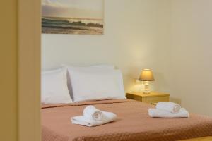 a bedroom with a bed with towels on it at Melia deluxe city view apartment in Agios Nikolaos +22 photos