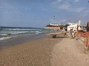 un grupo de personas de pie en una playa con una tabla de surf en Sea&Surf Deluxe Olga, en H̱adera 14 fotos más