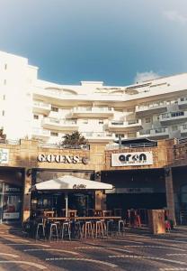 un edificio con mesas y sillas frente a un edificio en Sea&Surf Deluxe Olga, en H̱adera