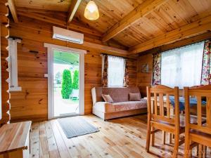 a log cabin with a couch and a window at Domki Romka in Mikołajki