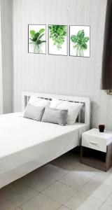 una camera da letto con un letto bianco con quattro immagini sul muro di Khoi Hostel ad Ho Chi Minh
