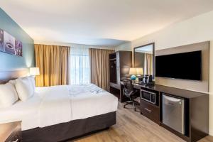 a hotel room with a bed and a flat screen tv at Sleep Inn on the Beach in Orange Beach