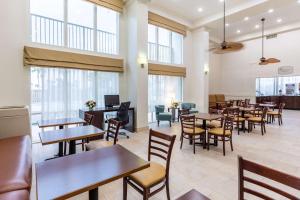 a restaurant with tables and chairs and windows at Sleep Inn on the Beach in Orange Beach