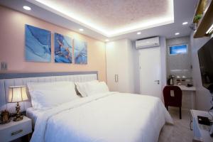 1 dormitorio con cama blanca y escritorio en Casa Julieta Boutique Hotel, en Davao City