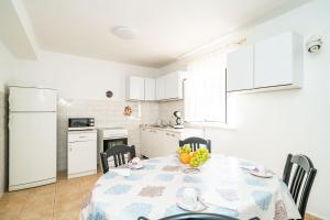 a kitchen with a table with a bowl of fruit on it at Apartment Kos in Dubrovnik