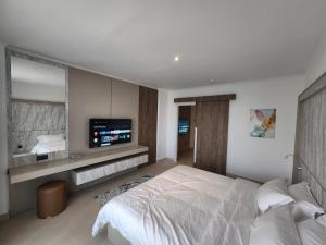 فندق إمبريال سويتس في المنامة: غرفة نوم فيها سرير وتلفزيون