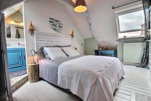 sypialnia z dużym łóżkiem i 2 oknami w obiekcie La chambre du capitaine w mieście Plérin