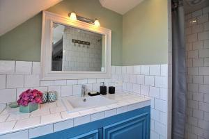 W łazience znajduje się umywalka i lustro. w obiekcie La chambre du capitaine w mieście Plérin